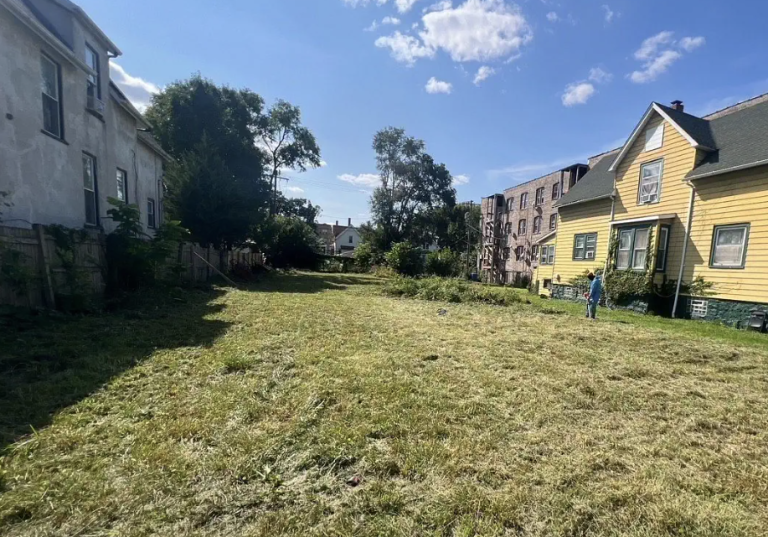 Man doing yard work in an empty field own by the Cook County Land Bank