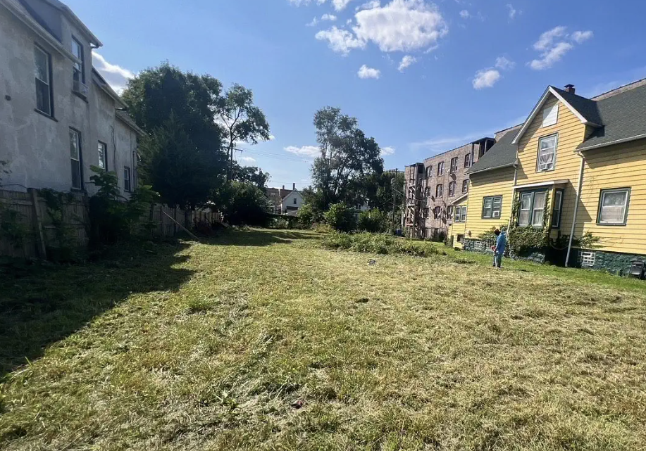 Man doing yard work in an empty field own by the Cook County Land Bank